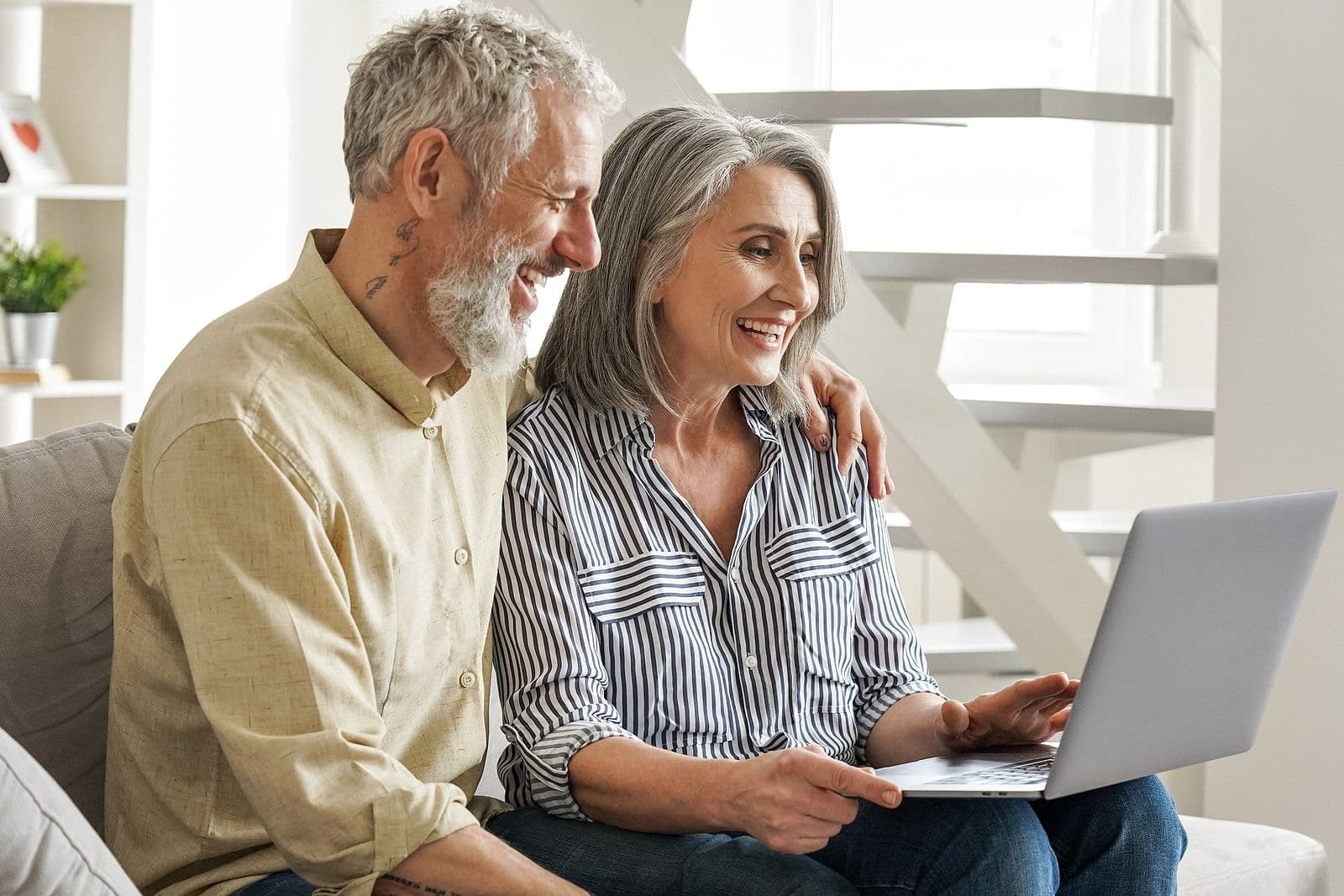 couple smiling looking at laptop screen